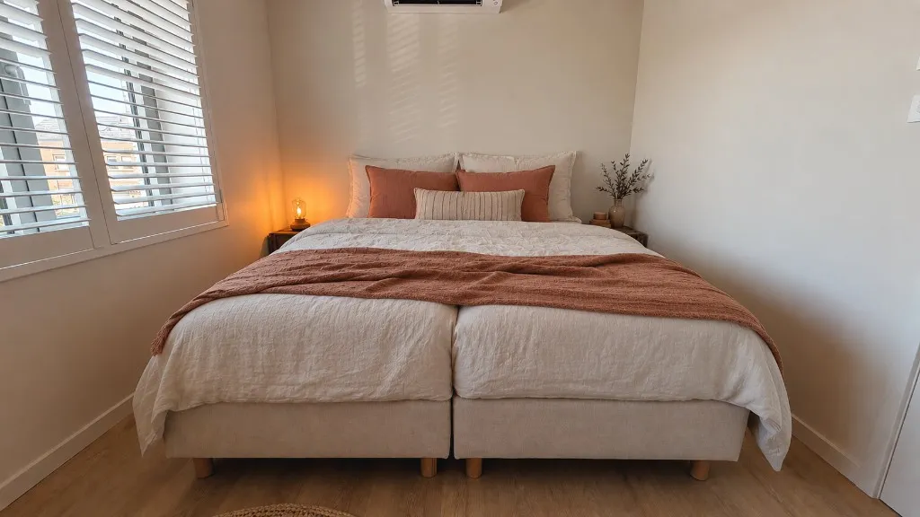 Kleine slaapkamer met tweepersoonsbed en terracotta accenten