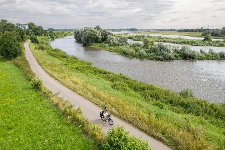 Fietser op het jaagpad langs de kronkelende Schelde