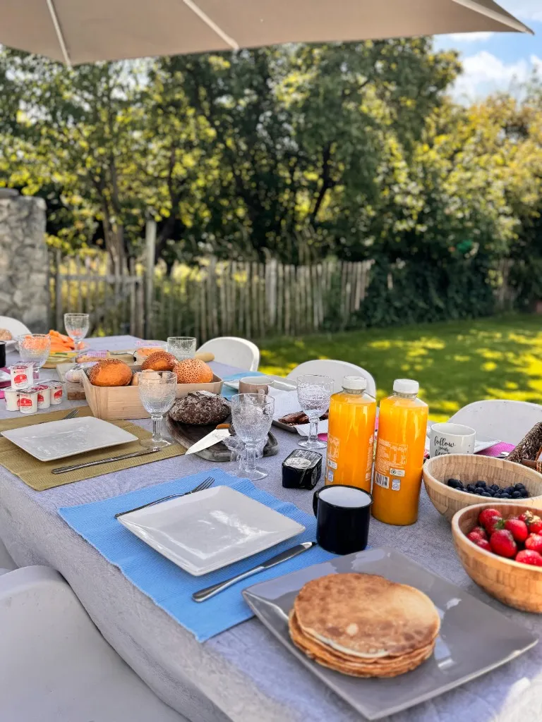 Uitgebreid ontbijt in de tuin met pannenkoeken, fruit en jus